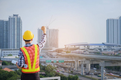 工程師或建筑師與防護安全帽檢查建筑圖紙呼叫支持團隊在建筑工地。工程建筑和建筑施工理念。軟焦點